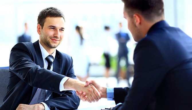 2 men in suits shaking hands