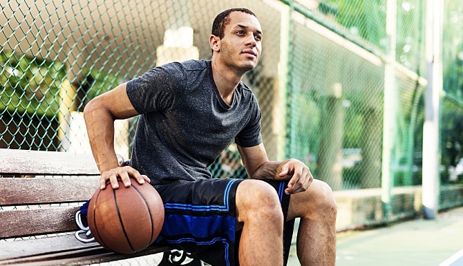 Man sitting on a bench with a basketball