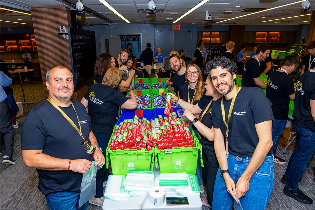 Employees assembling Clean the World hygiene kits with Colgate-Palmolive products.